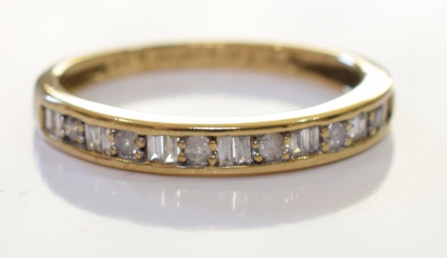 A 9ct gold diamond ring. Set with round brilliant cut diamonds along sige baguette cut diamonds,