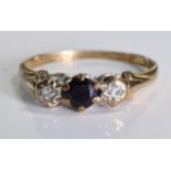 An 18ct gold three stone ring. A Sapphire centre stone mounted in between two diamonds