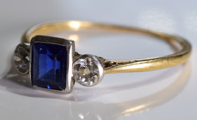A sapphire and diamond ring. The square-shape sapphire with old-cut diamond sides to the tapered - Image 3 of 3