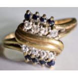 A 9ct gold diamond & sapphire ring. A Diamond and sapphire twist ring set in 9 ct gold. 3.4grms -