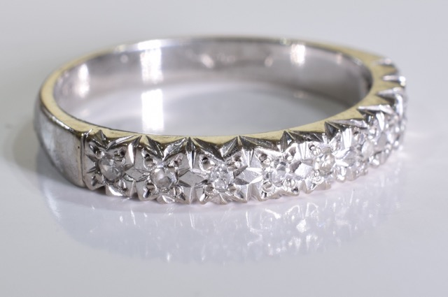 An 18ct white gold diamond ring. A half eternity ring set with brilliant cut diamonds in an 18ct