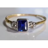 A sapphire and diamond ring. The square-shape sapphire with old-cut diamond sides to the tapered