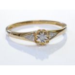 A 9ct gold diamond ring. A single diamond, with two further diamonds on each shoulder. 1.1 grm -