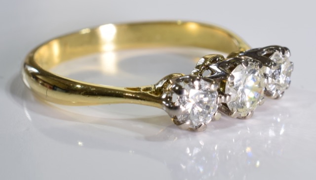 A diamond three-stone ring. The graduated brilliant-cut diamond line, to the tapered shoulders and - Image 2 of 3