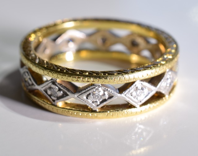 A 18CT Gold diamond full-circle eternity ring. Of bi-colour openwork design, the brilliant-cut