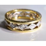 A 18CT Gold diamond full-circle eternity ring. Of bi-colour openwork design, the brilliant-cut