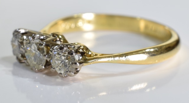 A diamond three-stone ring. The graduated brilliant-cut diamond line, to the tapered shoulders and - Image 3 of 3