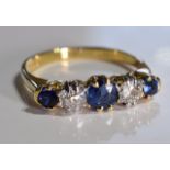 A mid 20th century 18ct gold sapphire and diamond five-stone ring. Size L. The circular-shape