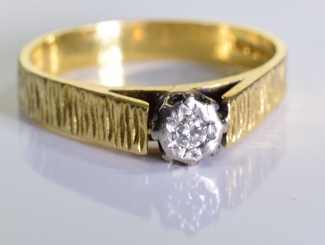 An 18ct Gold diamond solitaire ring. One brilliant cut diamond in an illusion setting, set in 18ct