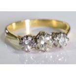 A diamond three-stone ring. The graduated brilliant-cut diamond line, to the tapered shoulders and