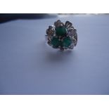 Intricate 925 sterling silver ring with petals and "diamond cut" details and 3 emeralds in approx