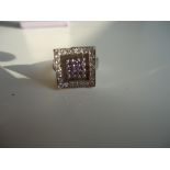 Interesting square and concave ring in 10k white gold adorned with clear and lavender high grade