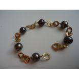 This charming pearl bracelet features six 8mm black tahitian pearls and 18k yellow gold links. The