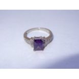 Dainty ring in 10K white gold with an emerald cut amethyst surrounded by high grade cubic zirconia.