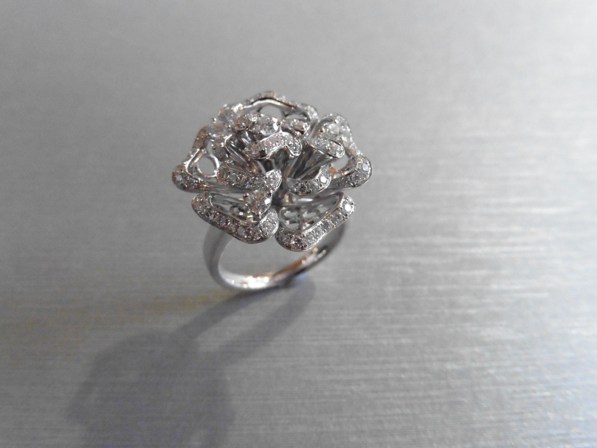 Brand new 18ct white gold high set fancy dress ring. Set in a flower design with small brilliant cut