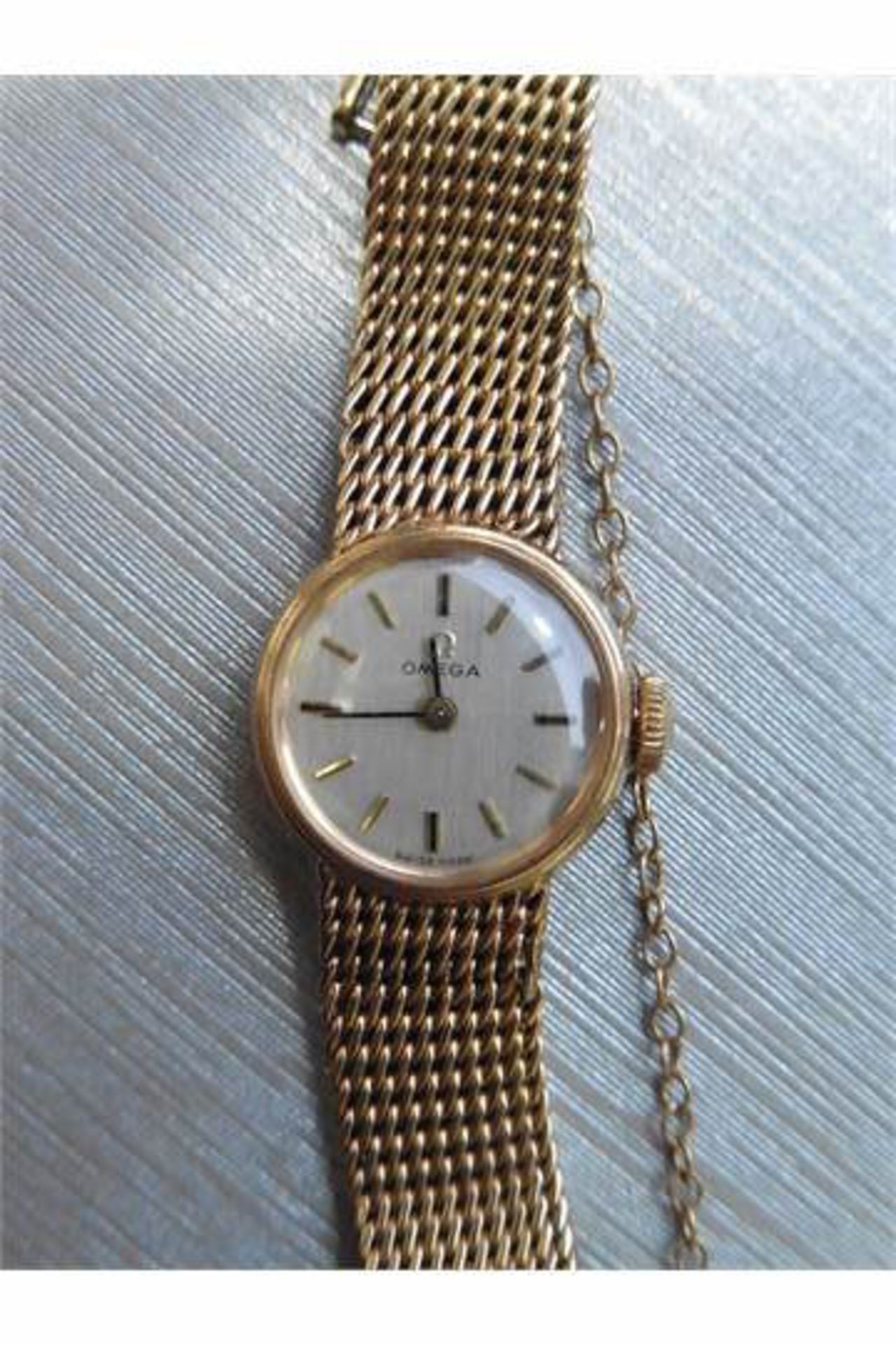 Pre-owned ladies 9ct yellow gold omega watch. Small round face with champagne coloured dial,