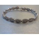 Brand new 10ct white gold fancy diamond bracelet set with oval sections of small baguette cut