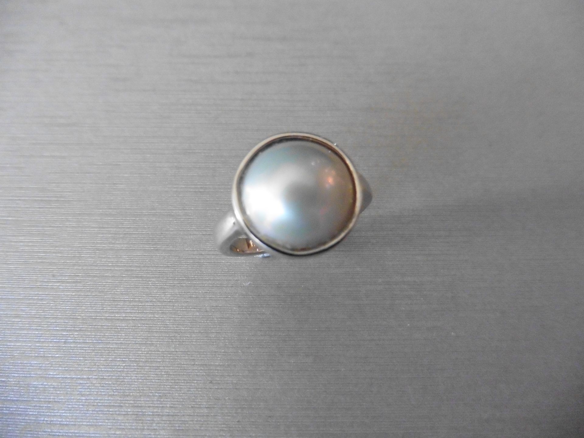 18ct white gold plain pearl dress ring. Set with a white pearl measuring 14mm width x 5mm deep.
