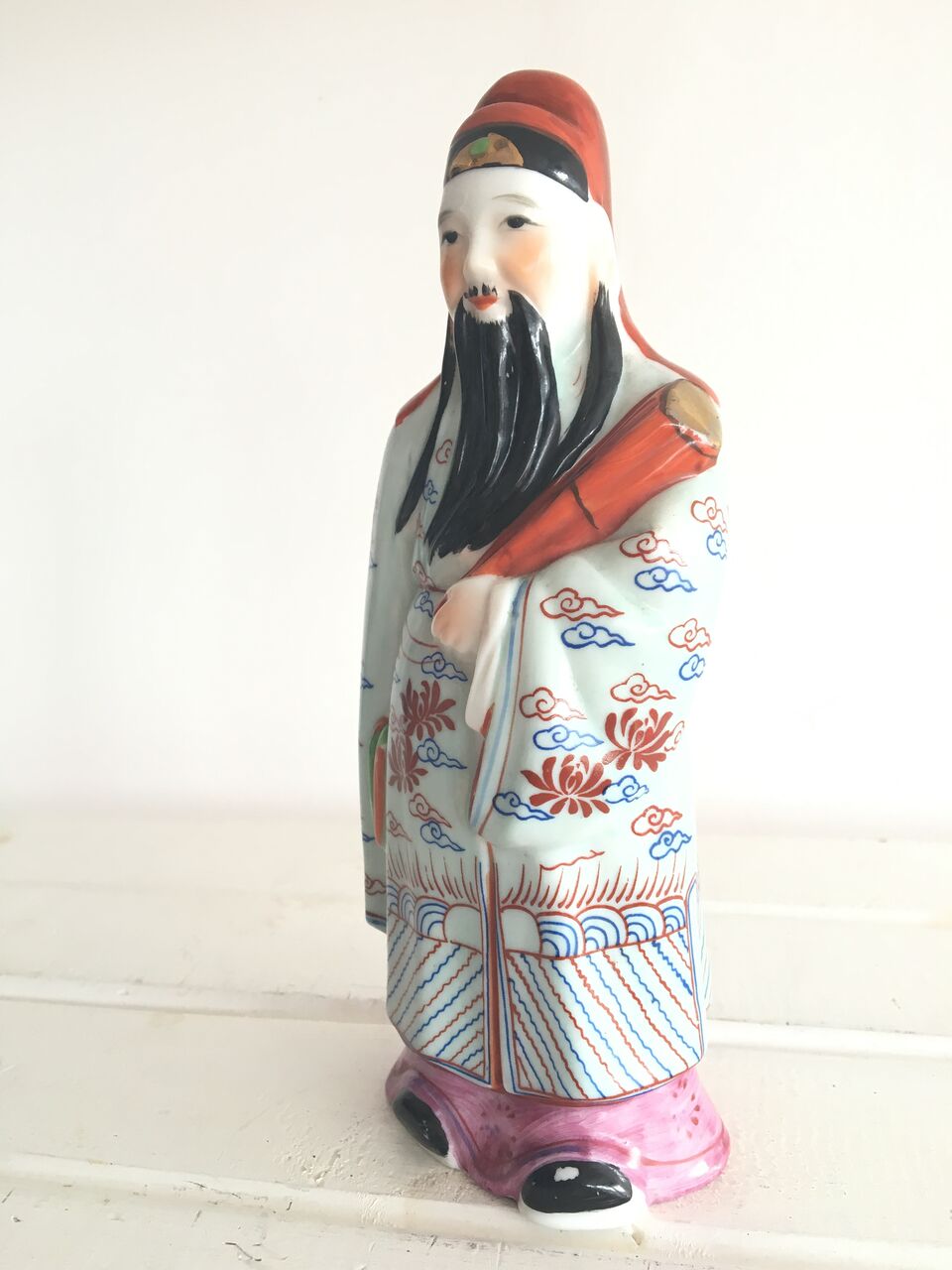 PORCELAIN FIGURINE OF A CHINESE IMMORTAL. 20CM. NUMBERS STAMPED TO UNDERSIDE. SMALL GLAXE RUB TO