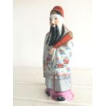 PORCELAIN FIGURINE OF A CHINESE IMMORTAL. 20CM. NUMBERS STAMPED TO UNDERSIDE. SMALL GLAXE RUB TO