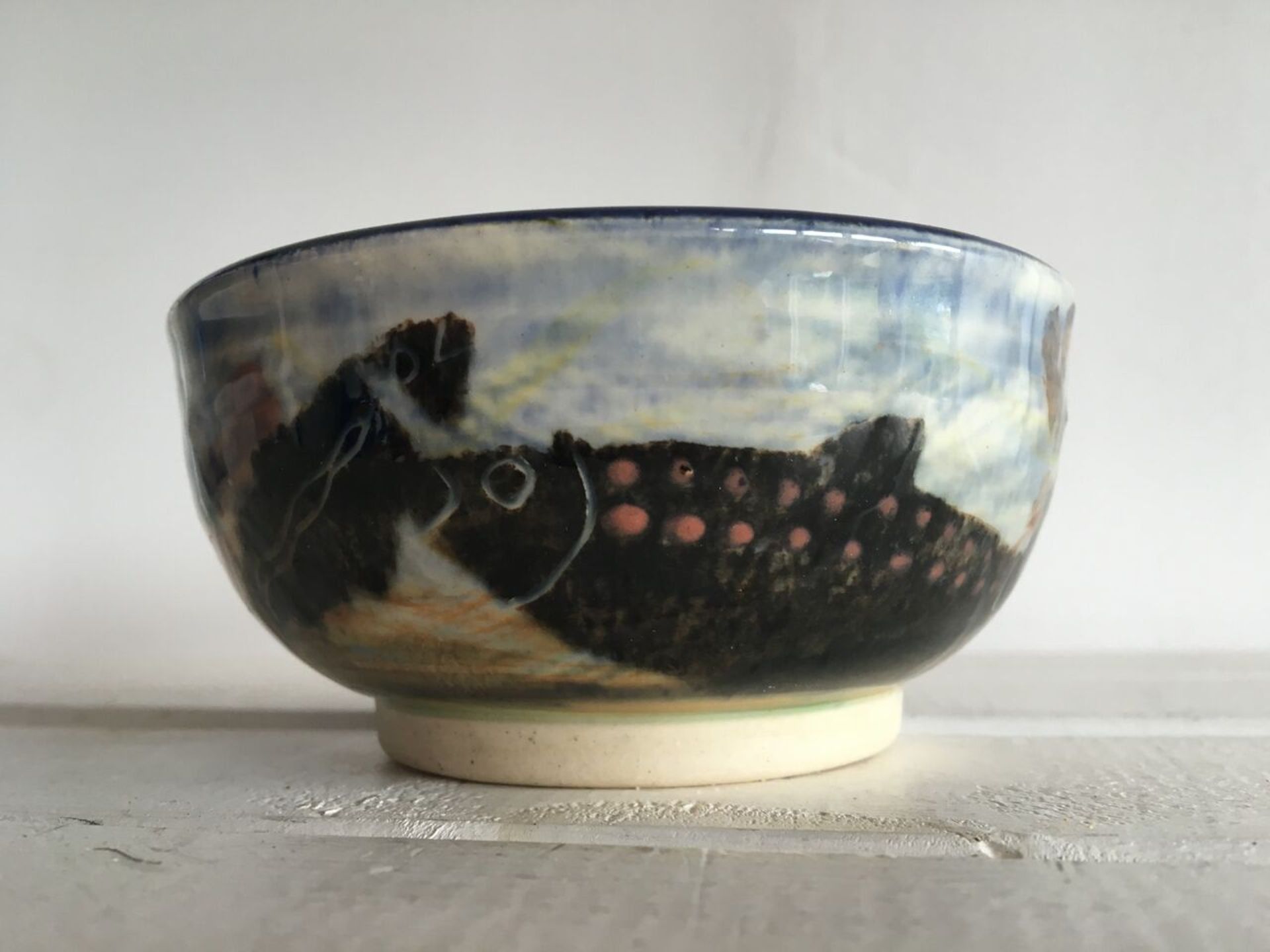 SIGNED GWILI POTTERY BOWL HAND DECORATED WITH FISH. NO OBVIOUS DAMAGE - 10CM DIAMETER. FREE UK