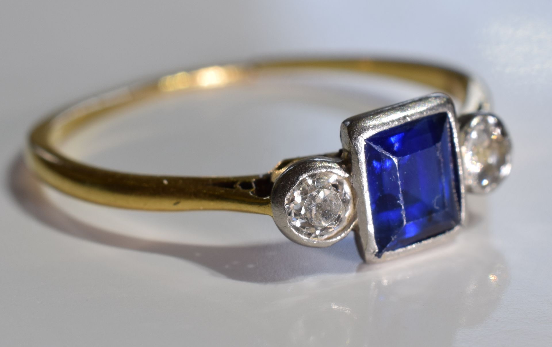 A sapphire and diamond ring. The square-shape sapphire with old-cut diamond sides to the tapered - Image 2 of 3