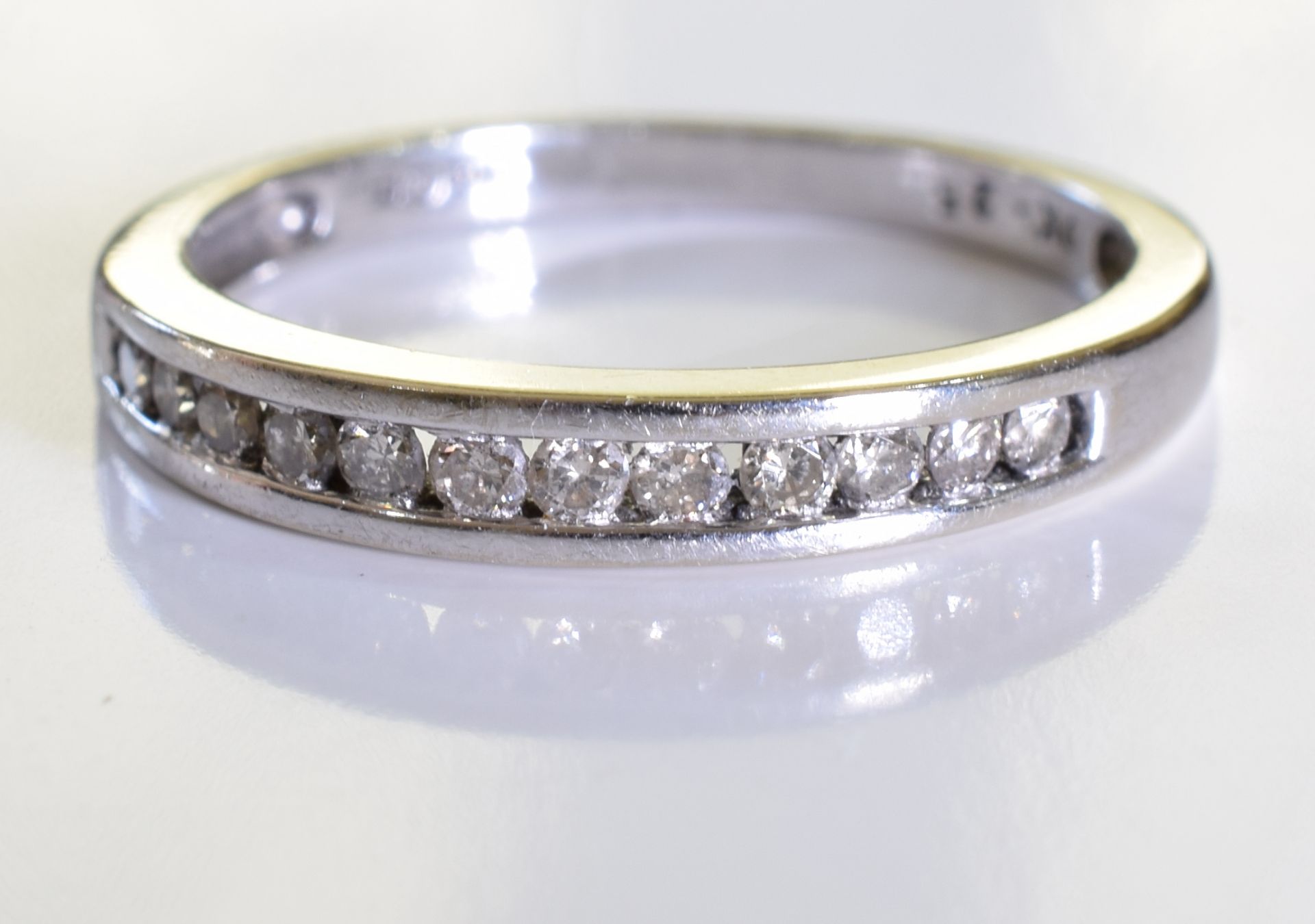 An 18ct gold diamond half-circle eternity ring. designed as a brilliant-cut diamond line, to the