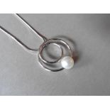 18ct white gold pearl pendant. Swirl circle design with a white pearl attached at the bottom, 9mm.