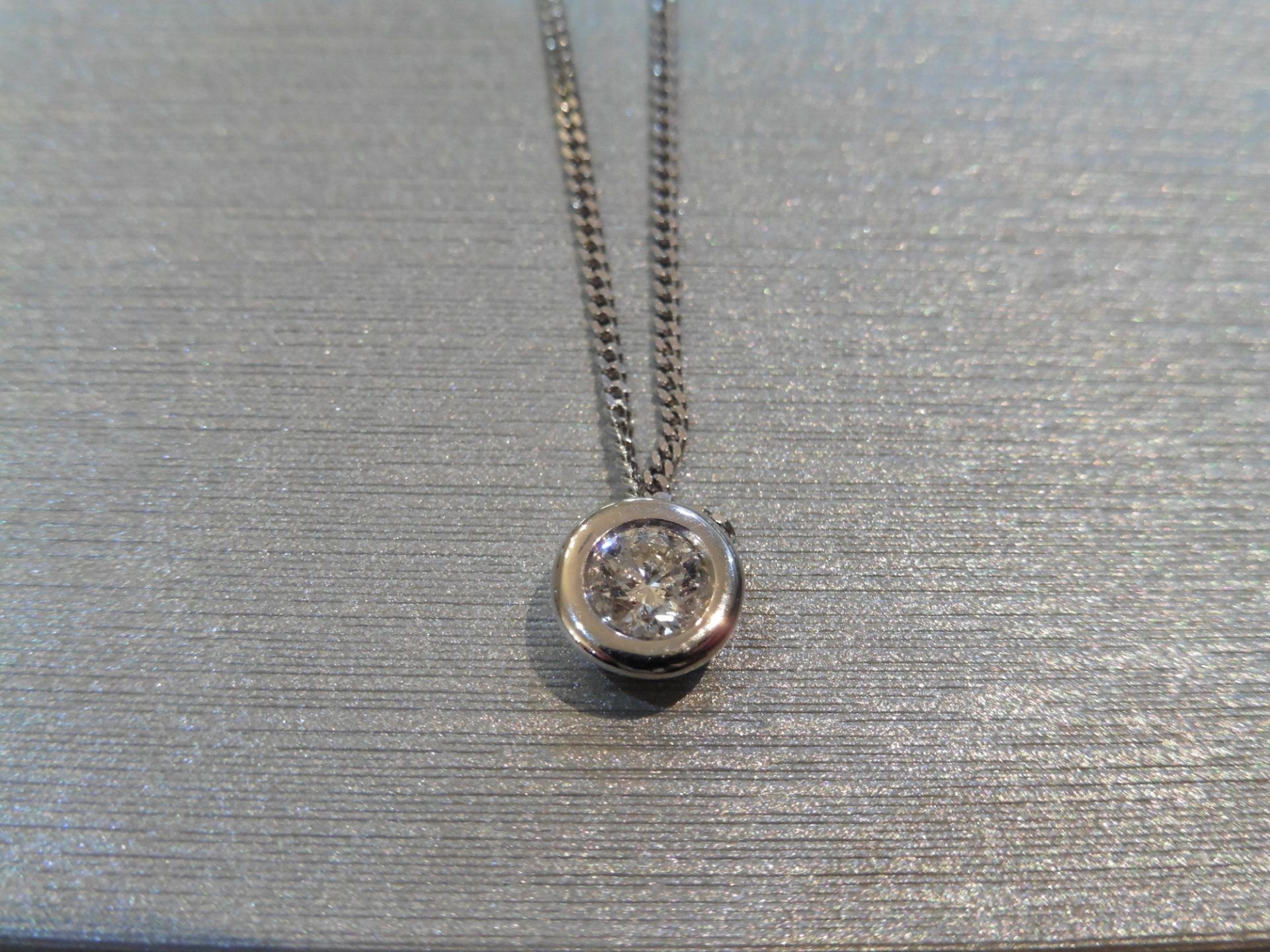 Solitaire diamond pendant set with a 0.40ct brilliant cut diamond. Set in a heavy rub over setting