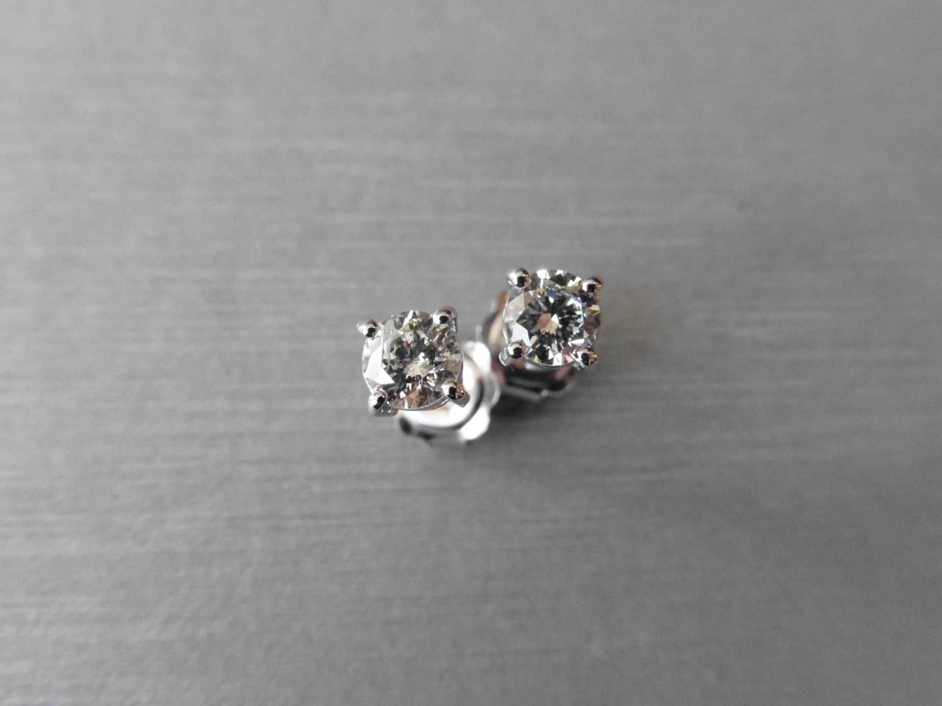 Solitaire diamond stud earrings each set with a brilliant cut diamond weighing a total of 0.82ct. - Image 2 of 3