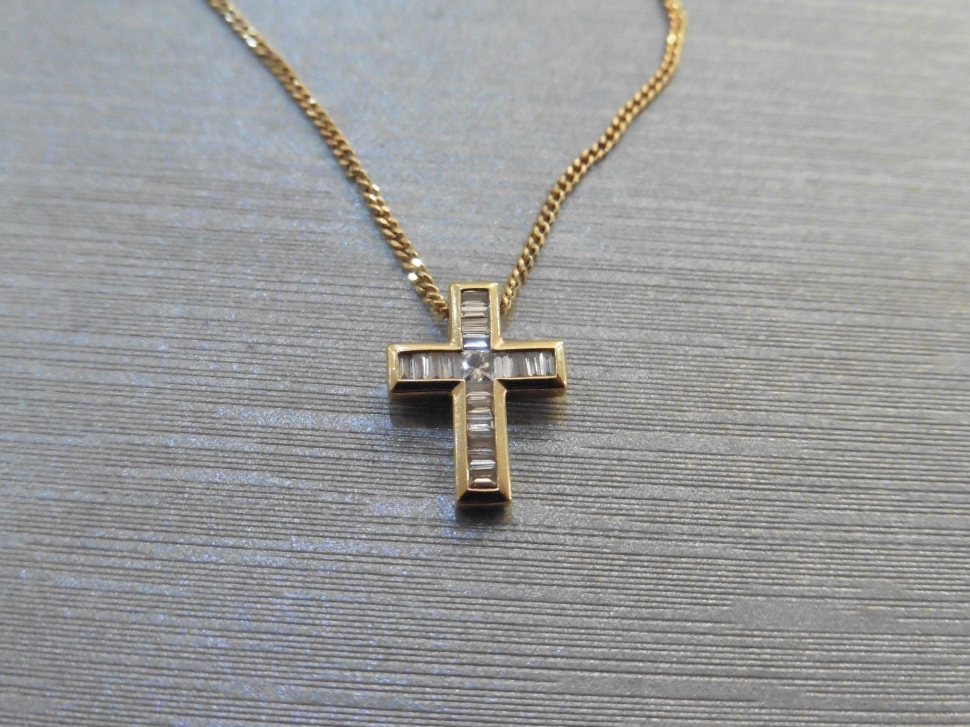Diamond cross pendant set with 1 small princess cut diamond in the centre and surrounded by baguette