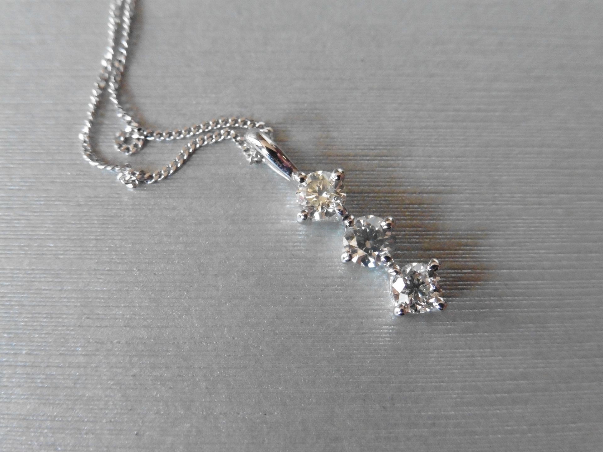 Trilogy pendant set with 3 small brilliant cut diamonds of H/I colour weighing a total of 0.60ct.