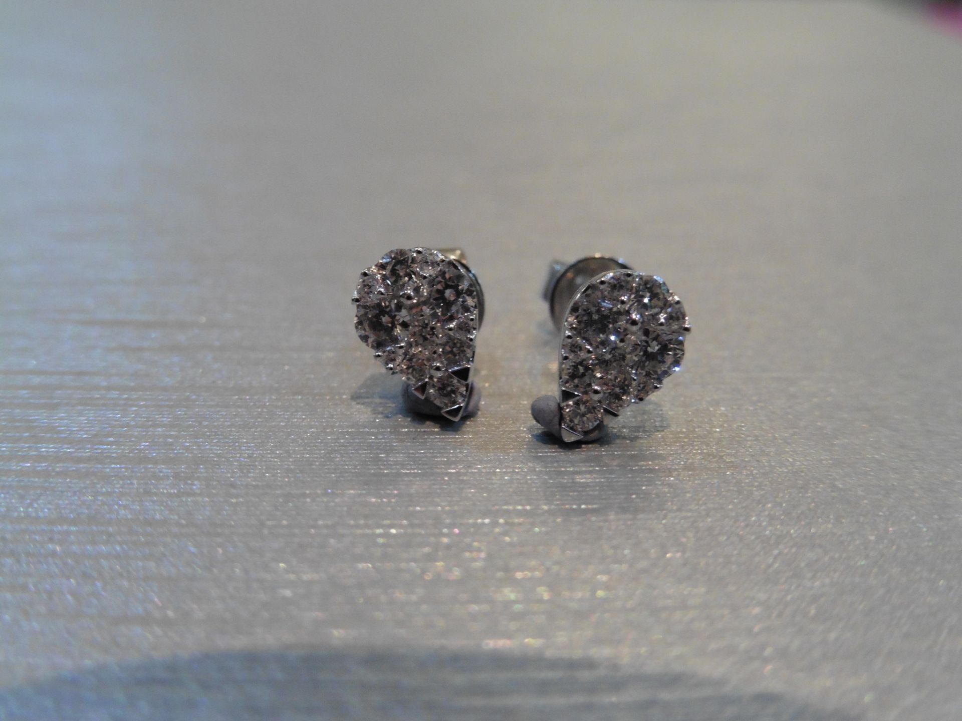 Pear shaped diamond earrings. Each is illusion set with small brilliant cut diamonds, weighing 0.