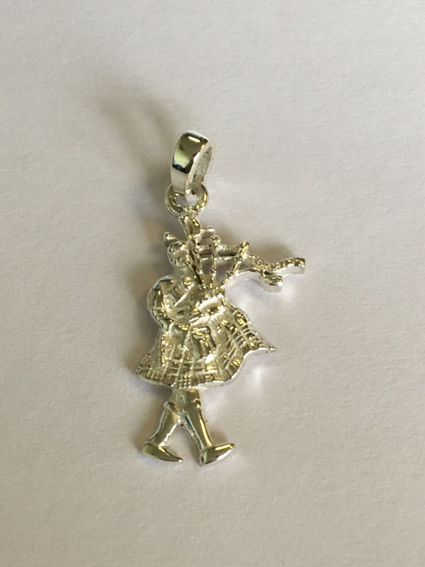 SILVER (STAMPED 925) CHARM OR PENDANT IN THE FORM OF A SCOTTISH PIPER. APPROX 2CM. FREE UK DELIVERY.