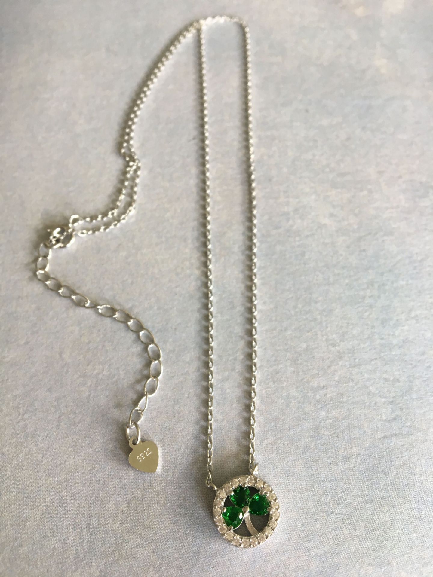 STUNNING STERLING SILVER (STAMPED 925) NECKLACE, ROUND PENDANT SET WITH GREEN STONES TO FORM A