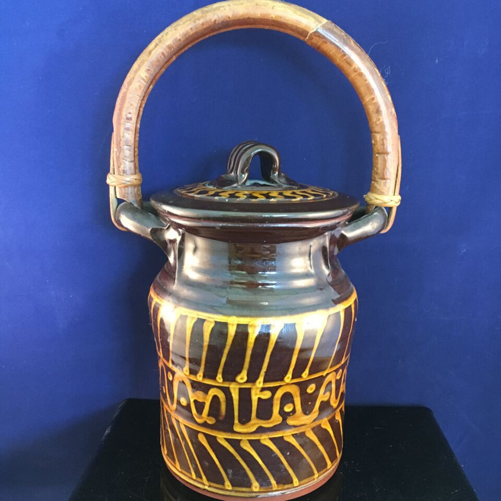 VINTAGE POTTERY SLIPWARE LIDDED JAR WITH A BAMBOO HANDLE. MEASURES 30CM HEIGHT (INC HANDLE) X