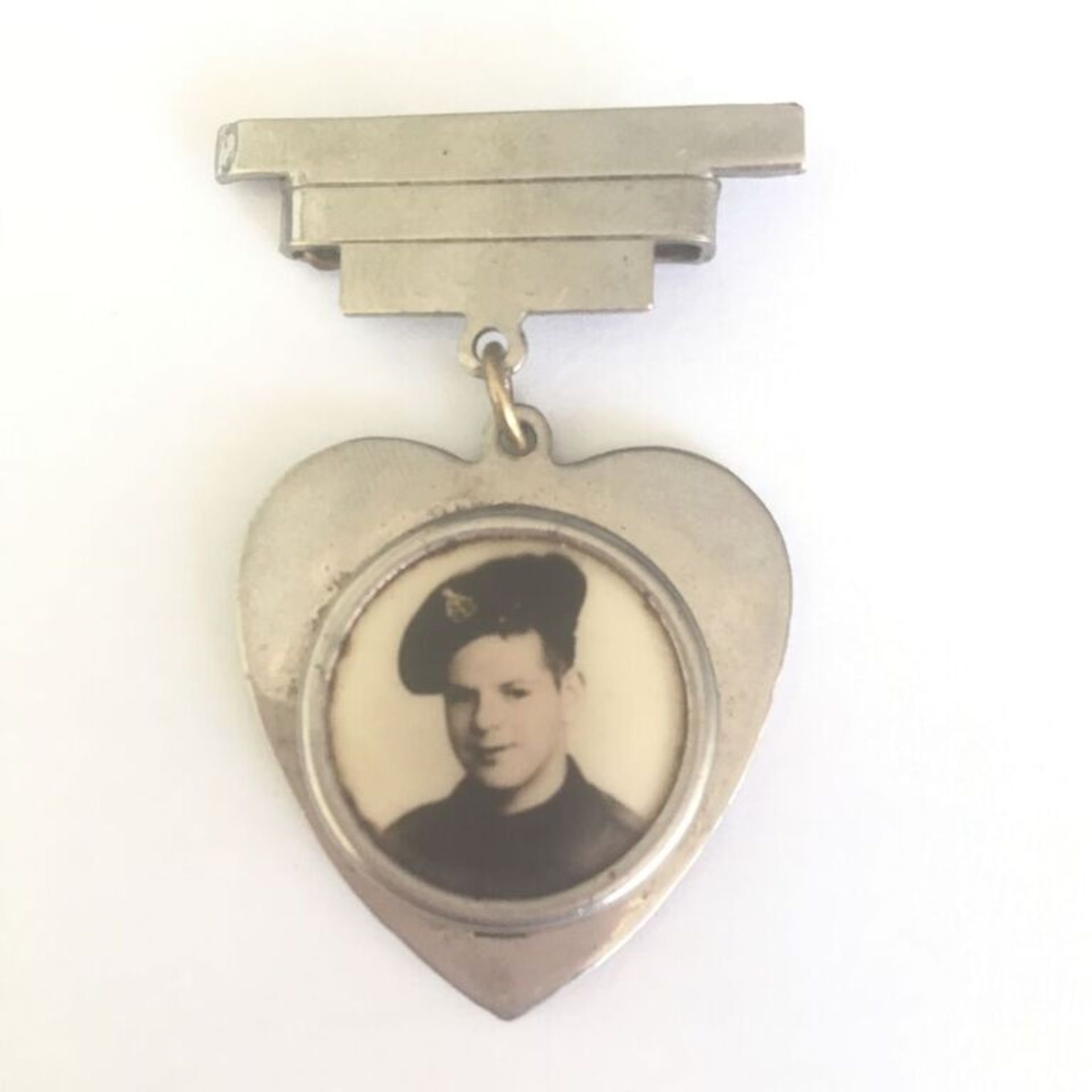 A WW2 ART DECO HEART SHAPED PORTRAIT BROOCH WITH PHOTOGRAPH OF VERY YOUNG SOLDIER