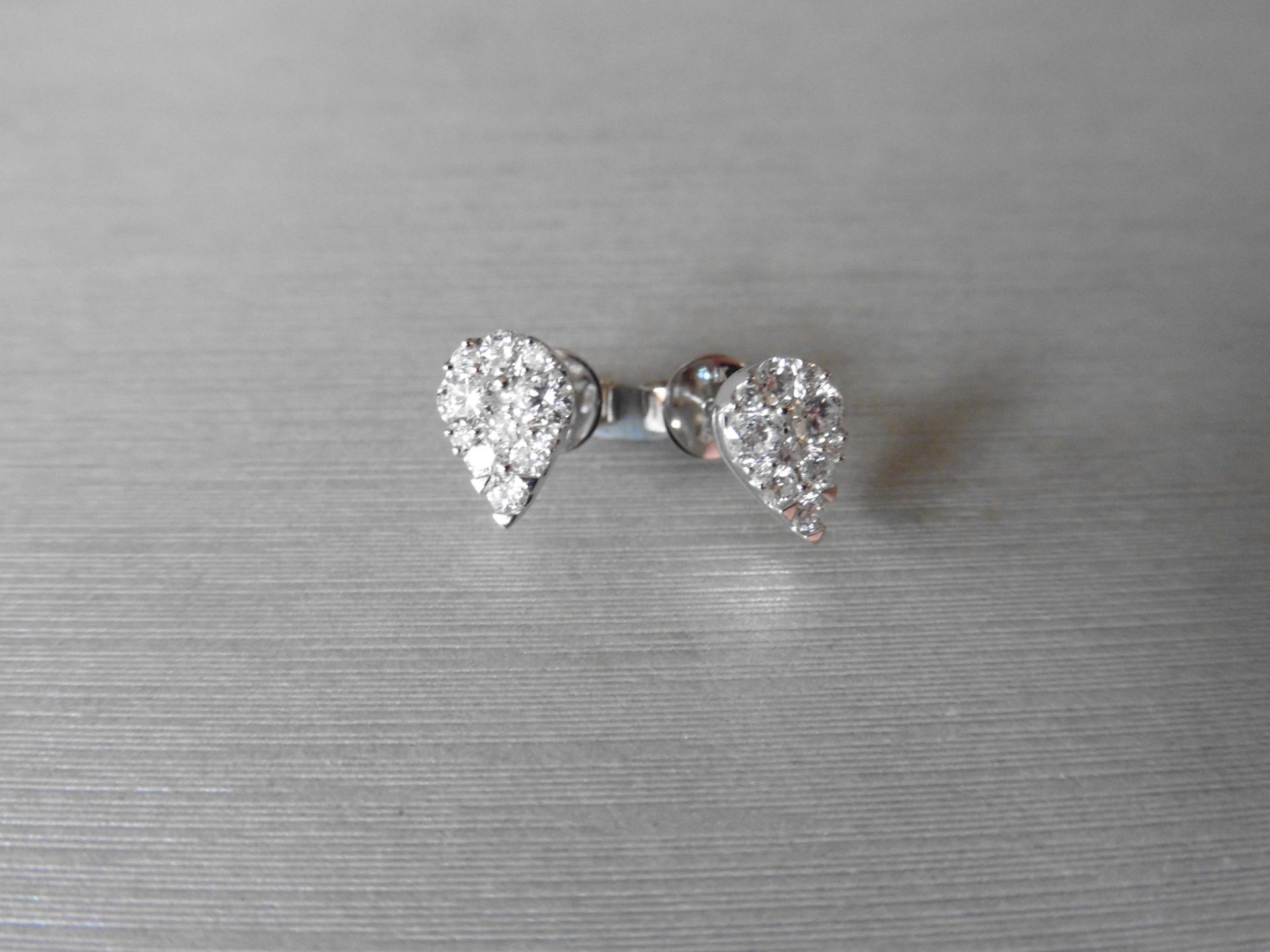 0.65ct Pear shaped diamond earrings. Each is illusion set with small brilliant cut diamonds, H/I