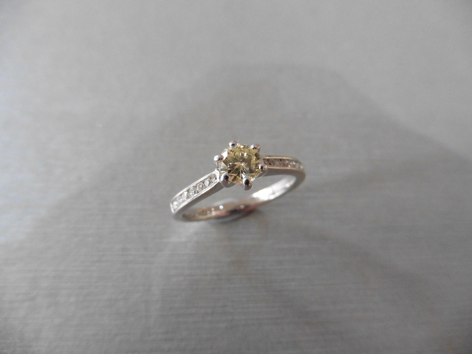 0.40ct Diamond set solitaire ring with a brilliant cut yellow diamond in the centre. The shoulders