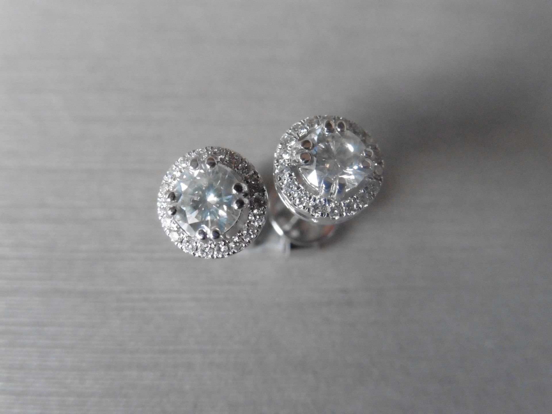 1.00ct diamond stud earrings each with a halo setting. 0.80ct total weight in the centre, H/I