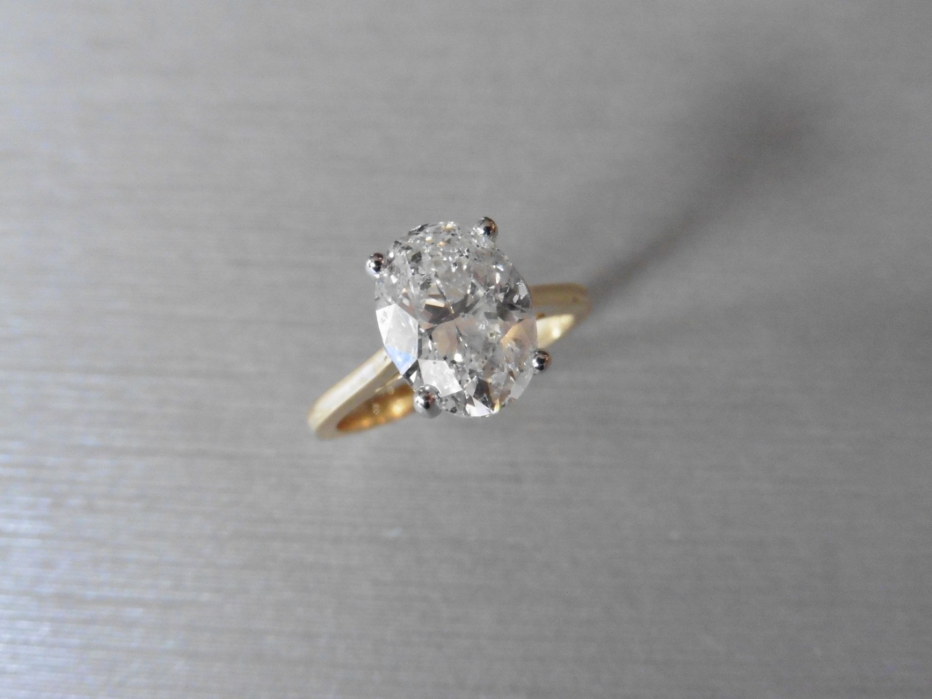 18ct gold diamond solitaire ring set with a 3.01ct oval cut diamond, H colour, Si2 clarity. 4 claw