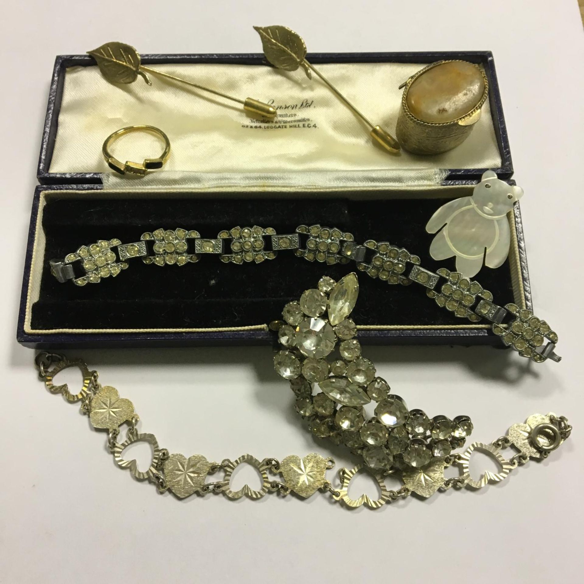 A small box of original Art Deco era costume jewellery, a mother of pearl bear brooch, pill box etc.