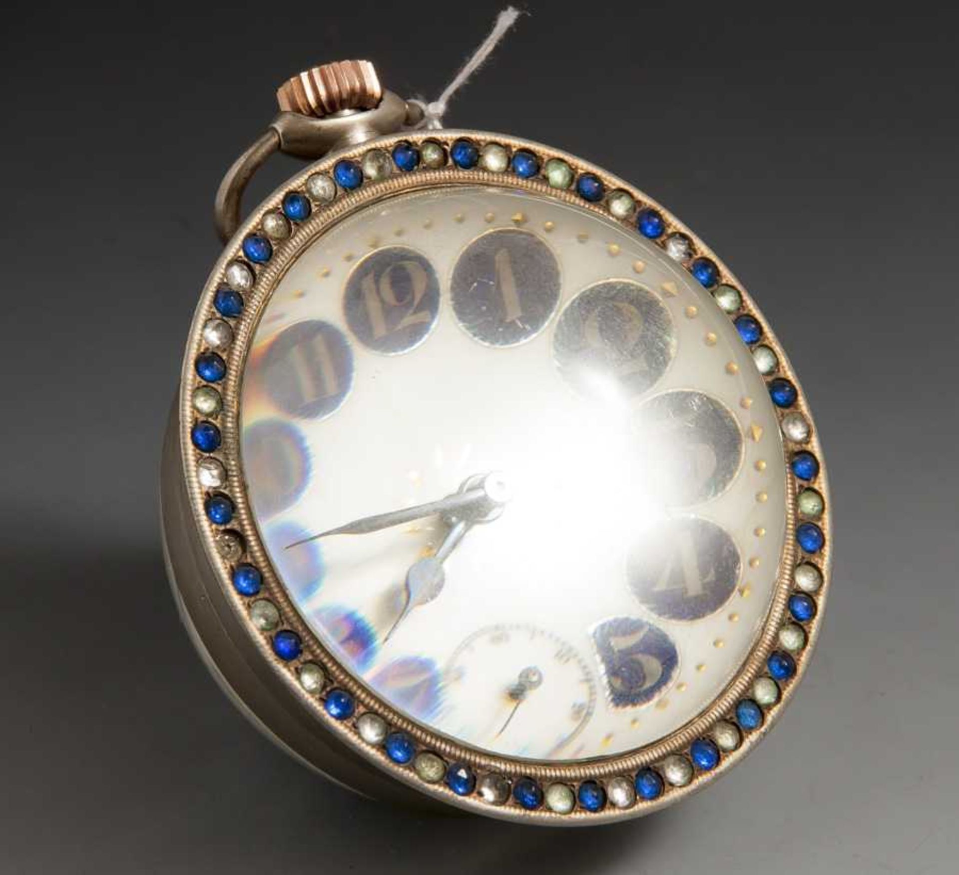 Tischuhr in Form einer Glaskugel, um 1900, Lünette mit farbigem Glassteinbesatz. H. ca. 9cm, DM