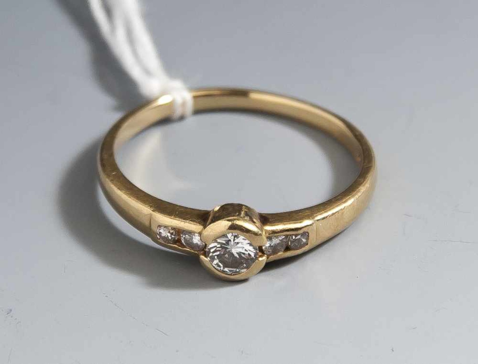 Damenring, Gelbgold 750, der Ringkopf ausgefasst mit 1 Brillant, ca. 0,10 ct/H/vsi und 4Brillanten