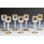 7 Gläser, um 1910, farbloses Glas, bernsteinfarben unterfangen u. goldstaffiert, überTellerfuß