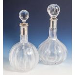 2 Karaffen aus klarem Glas, auf rundem Stand je bauchige Form, 1x davon gedrückt, mitumlaufendem