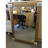 Gilt framed mirror with porcelain plaques on corners.