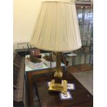 Lamp with a brass column and base with a white shade.