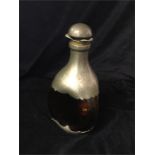 An amber glass bottle with pewter casing