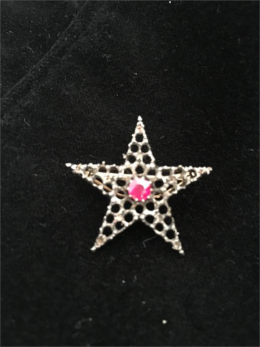 A star shaped brooch with gold back